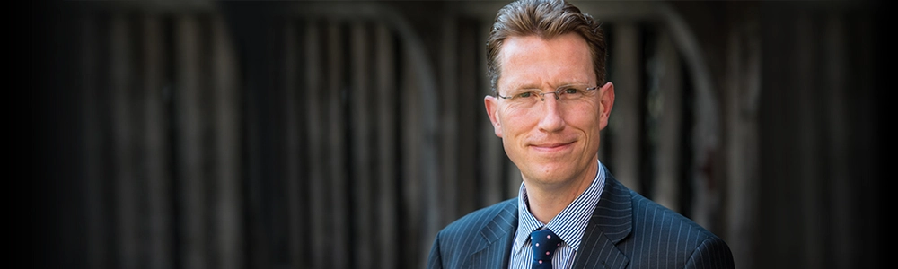 Bennet Carr posing with the School in the background